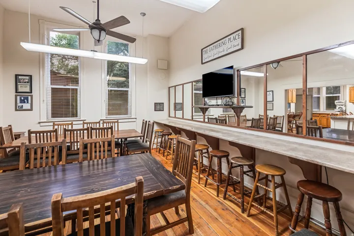 Dining space with light wood finished floors, a high ceiling, and a ceiling fan