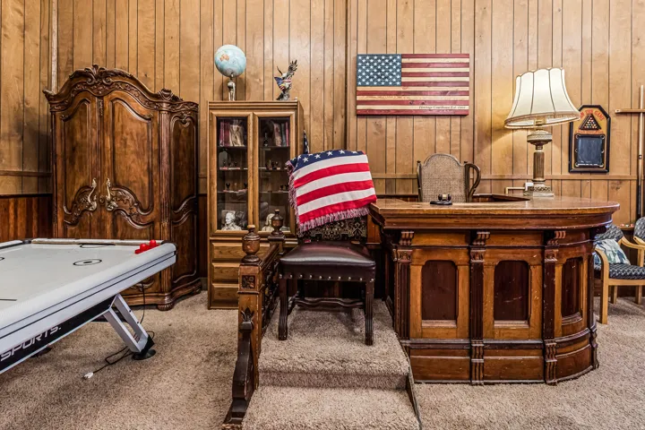 Home office featuring light carpet and wooden walls