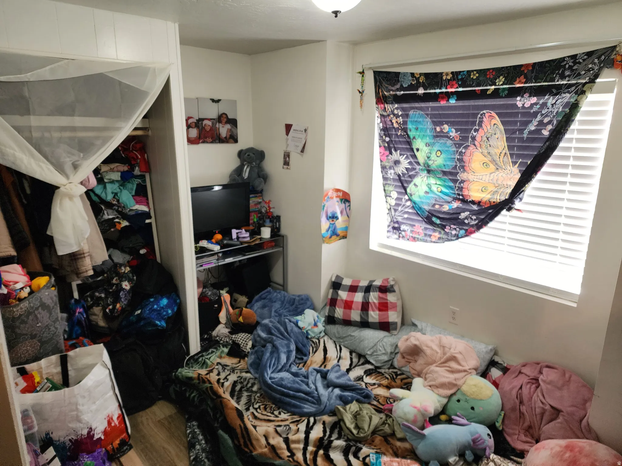 Bedroom with wood finished floors and a closet