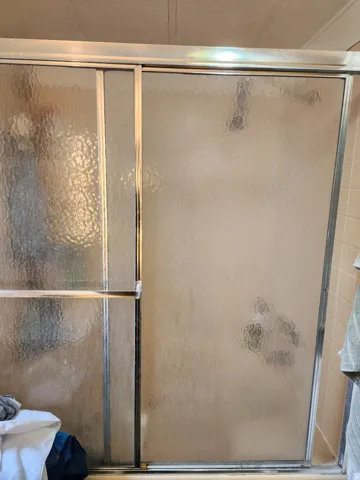 Full bath featuring a shower with door