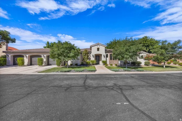 Mediterranean / spanish-style home featuring a tile roof, stucco siding, concrete driveway, and an attached garage