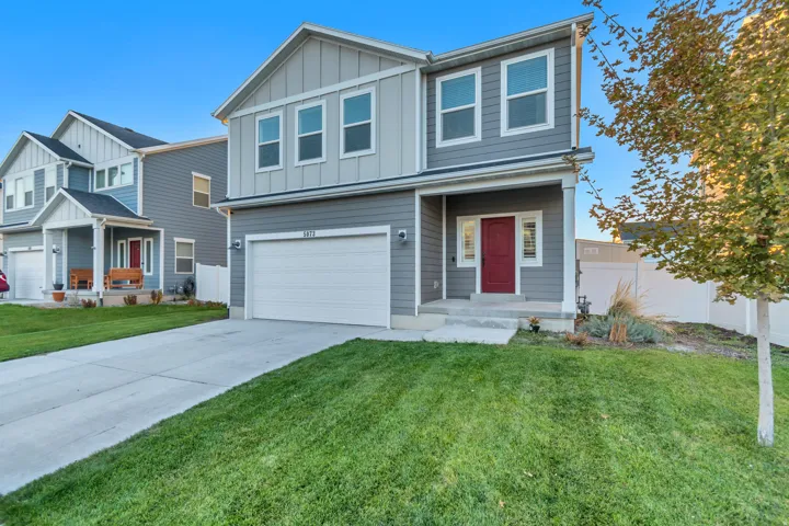 View of front of home featuring a garage, concrete driveway, and board and batten siding