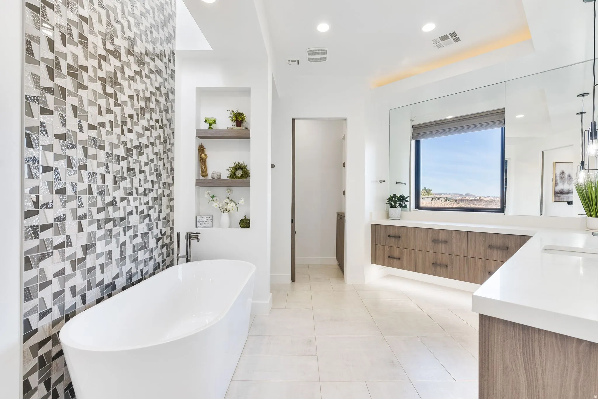 Full bathroom with vanity, a freestanding tub, built in shelves, light tile patterned floors, and tile walls