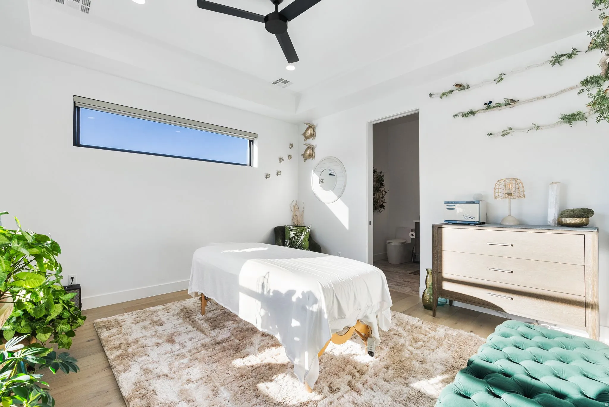 Bedroom featuring a raised ceiling, wood finished floors, ensuite bath, ceiling fan, and recessed lighting