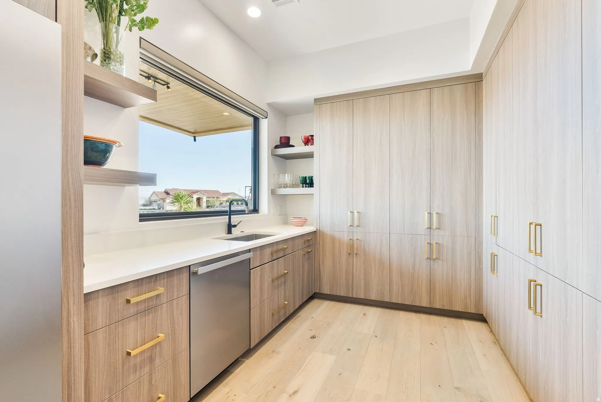 Kitchen featuring light wood finished floors, open shelves, dishwasher, modern cabinets, and recessed lighting