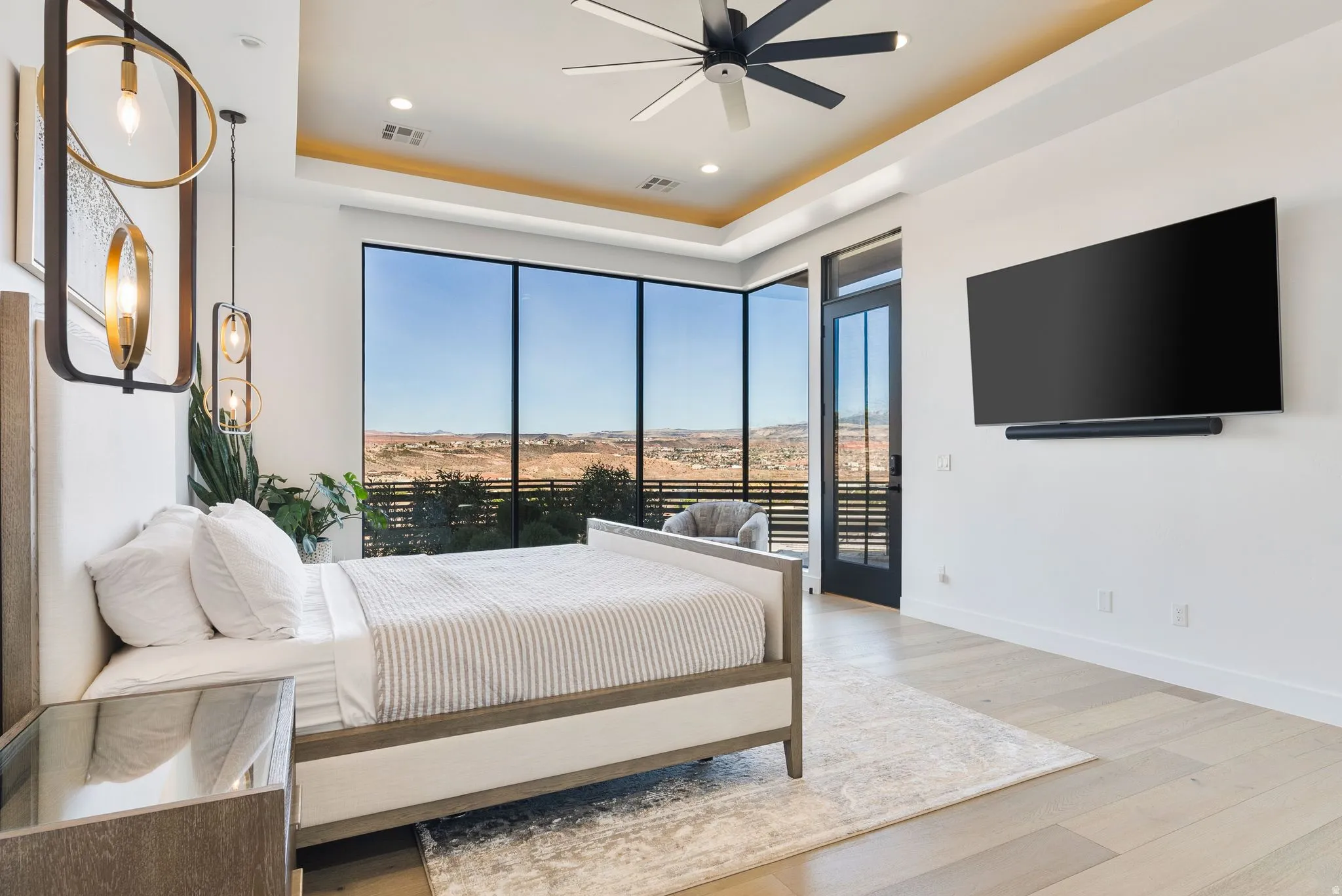 Bedroom featuring light wood finished floors, a tray ceiling, access to outside, a ceiling fan, and recessed lighting