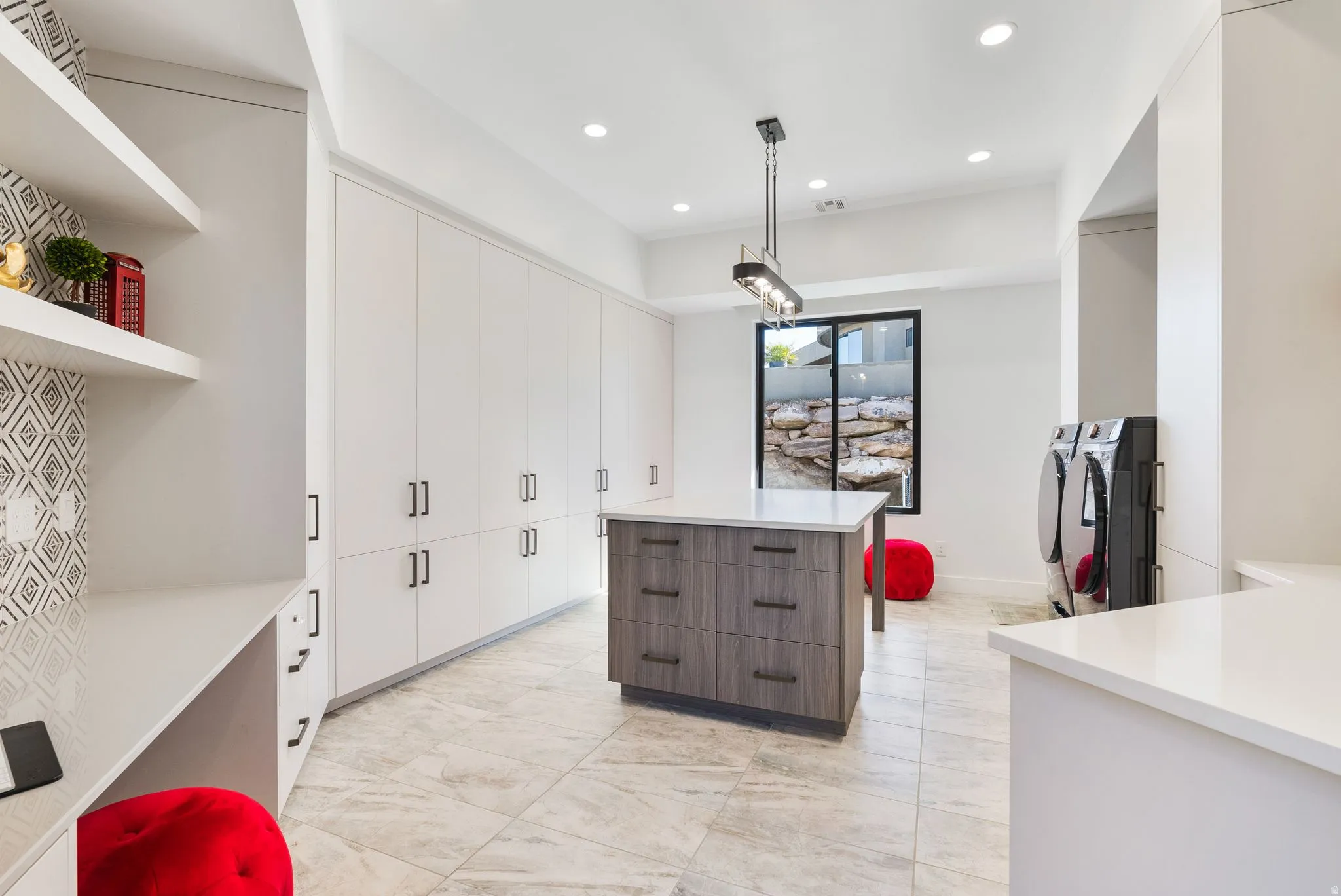 Kitchen with two tone color scheme, a kitchen island, open shelves, recessed lighting, and washing machine and clothes dryer