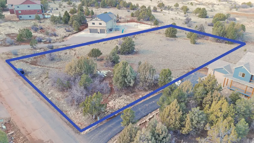 Aerial view of sparsely populated area featuring property boundaries highlighted and a desert landscape