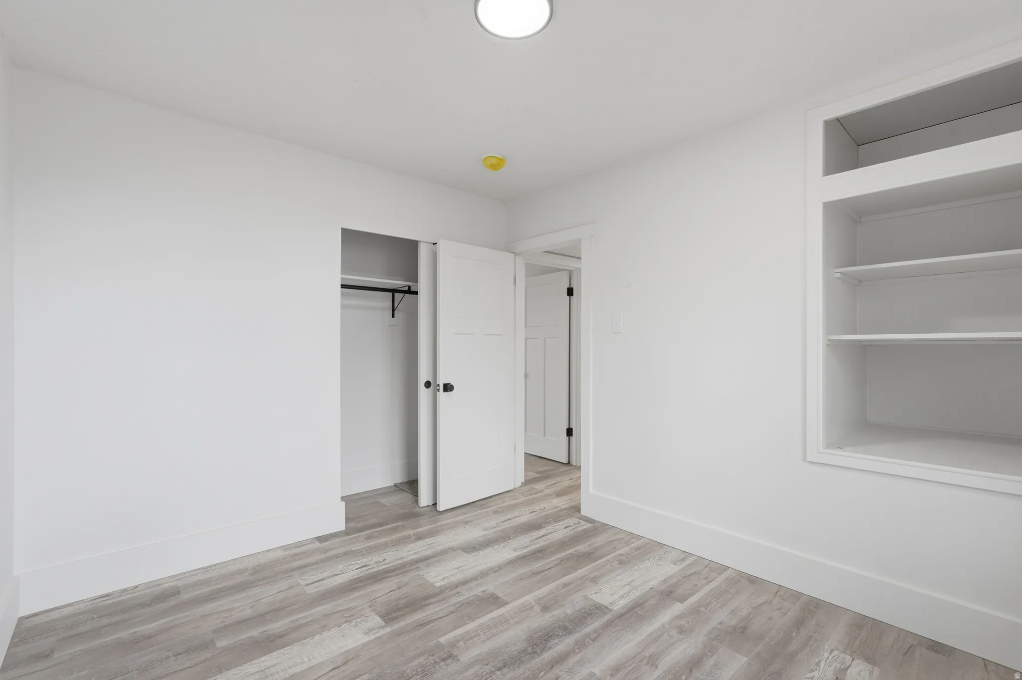 Unfurnished bedroom featuring light wood-type flooring and a closet