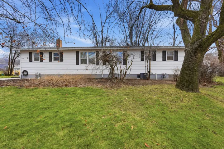 Ranch-style home with a chimney and a front lawn