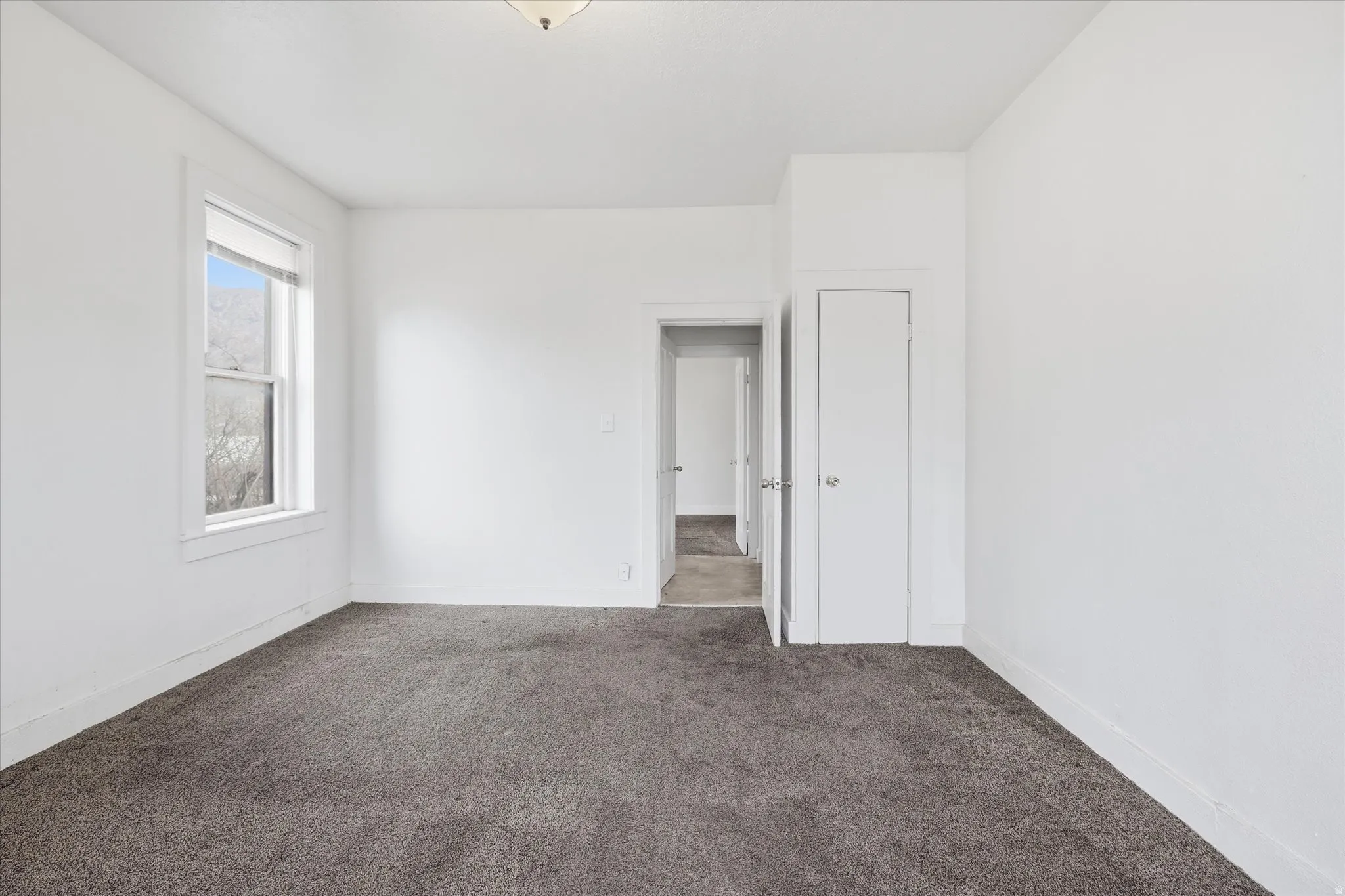 Spare room featuring carpet floors and baseboards