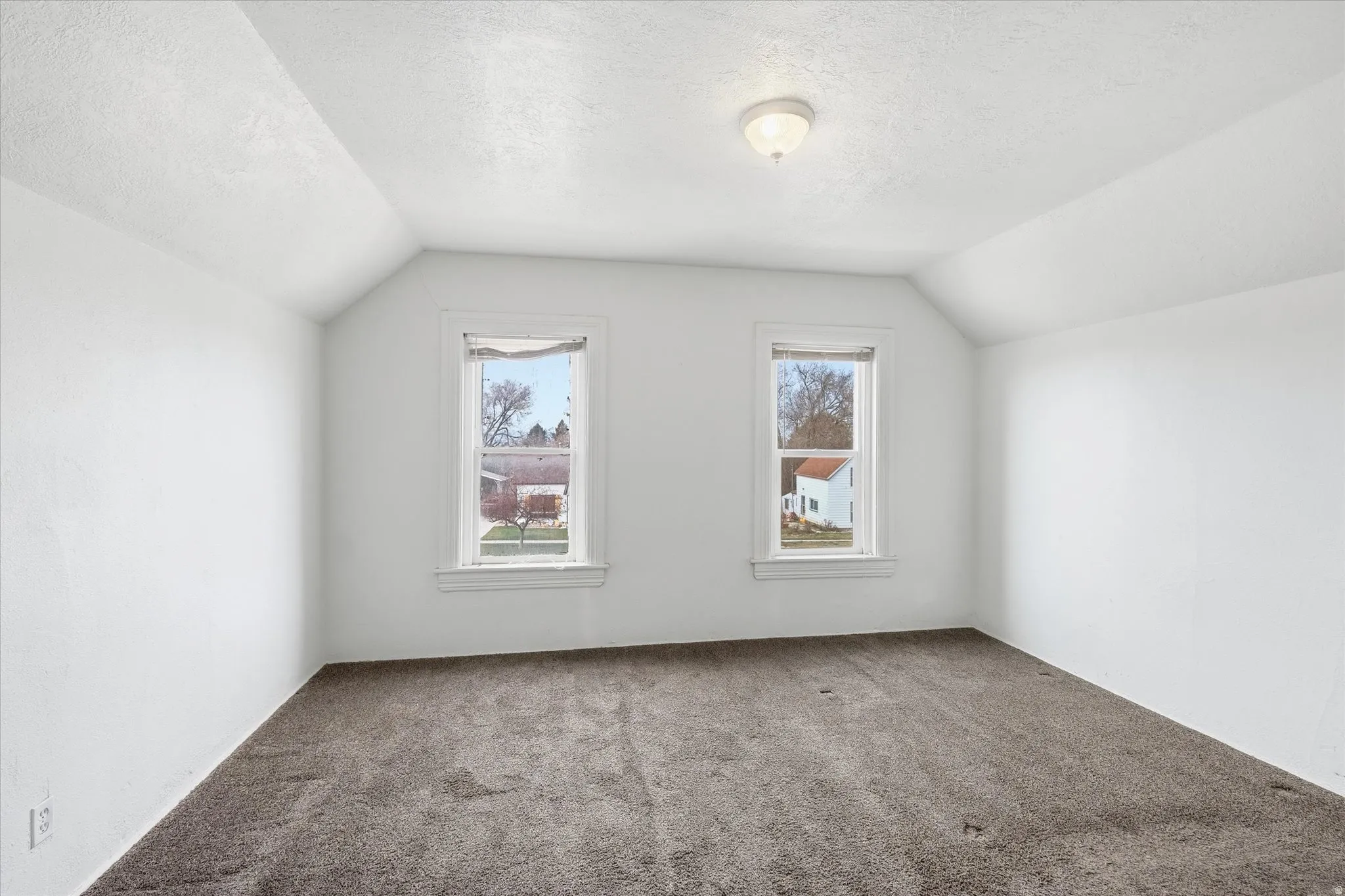 Bonus room with a textured ceiling and carpet flooring