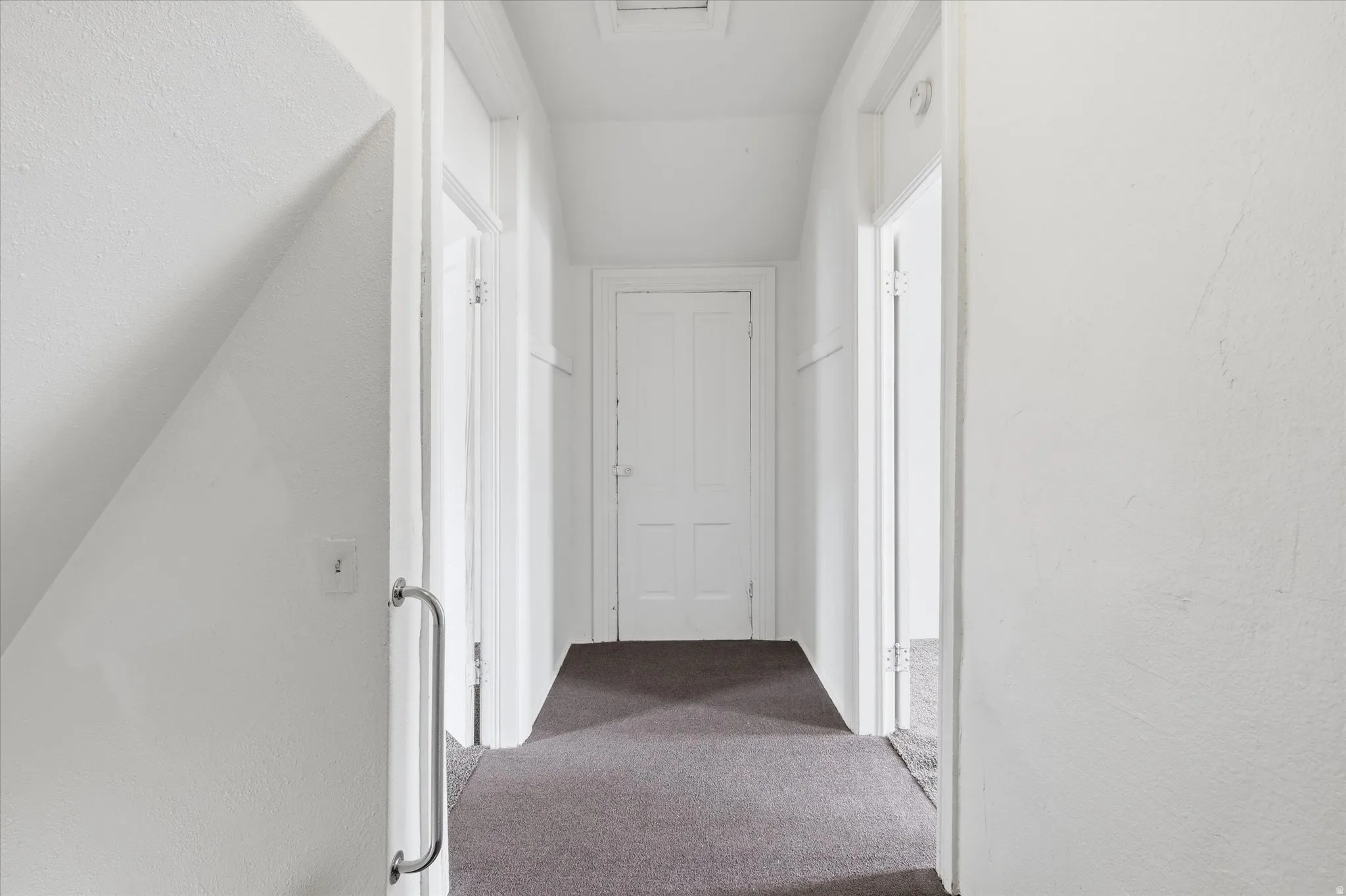 Hallway with carpet floors and a textured wall