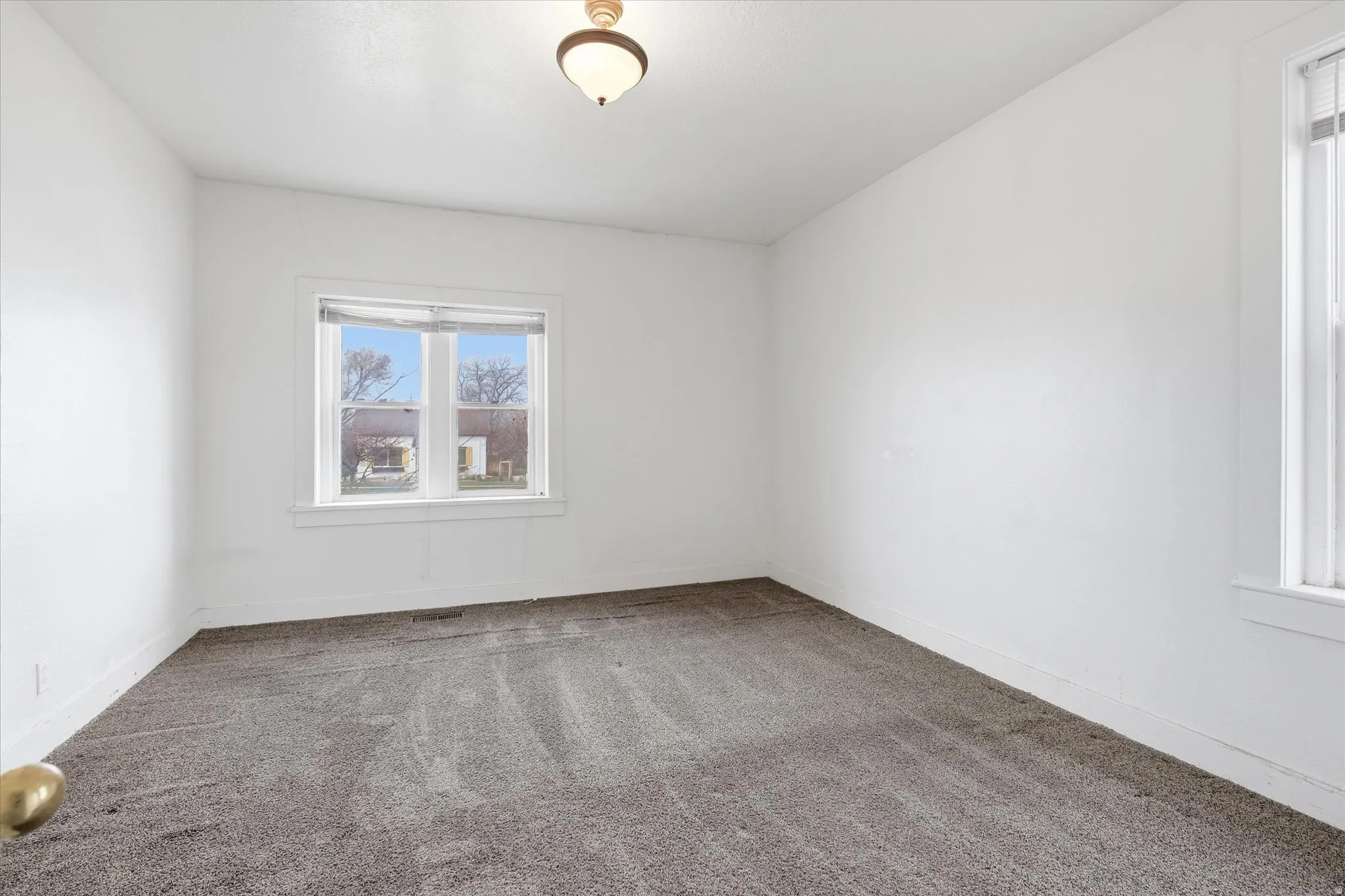 Carpeted spare room with baseboards