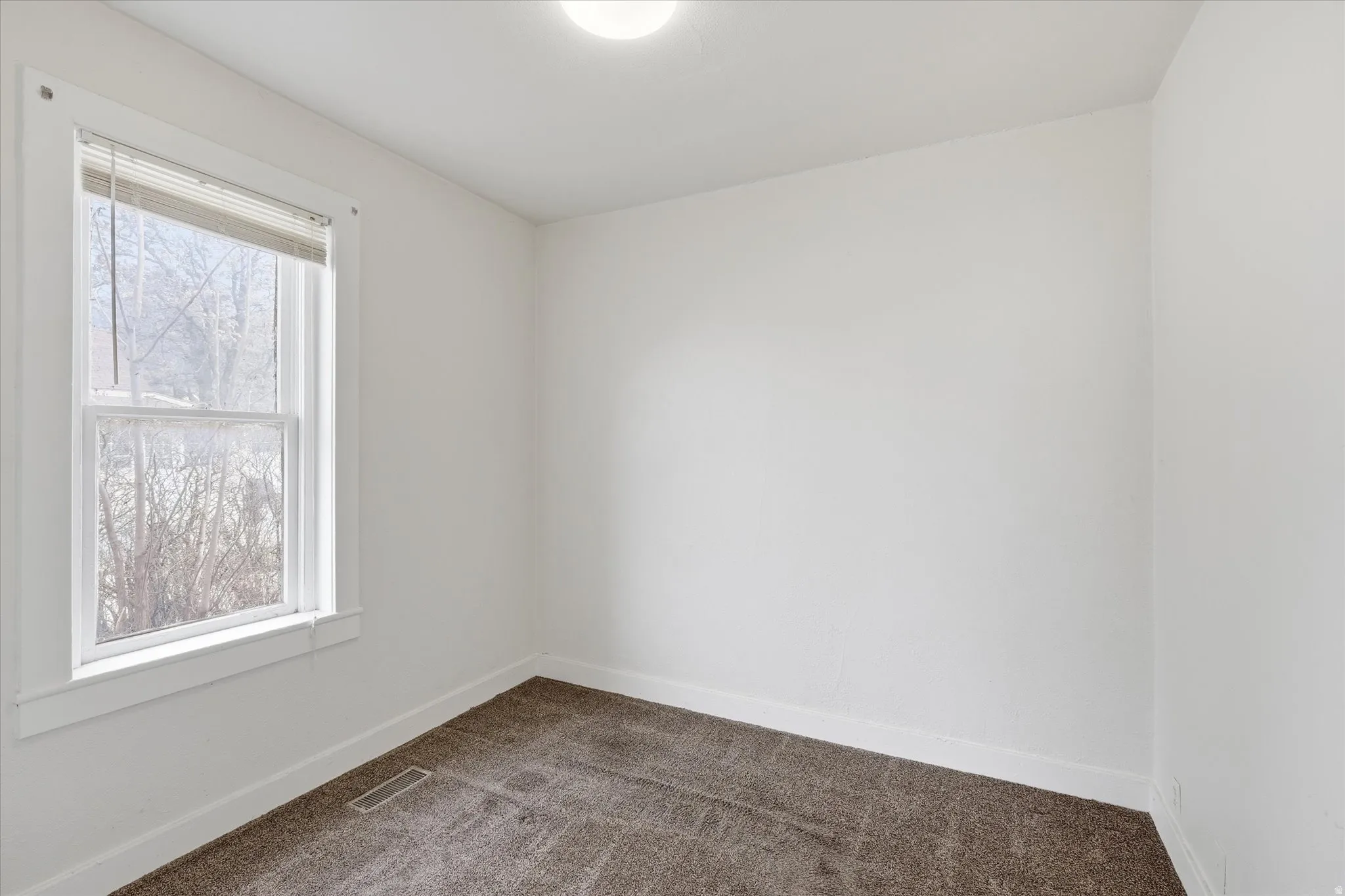 Empty room with dark carpet and baseboards