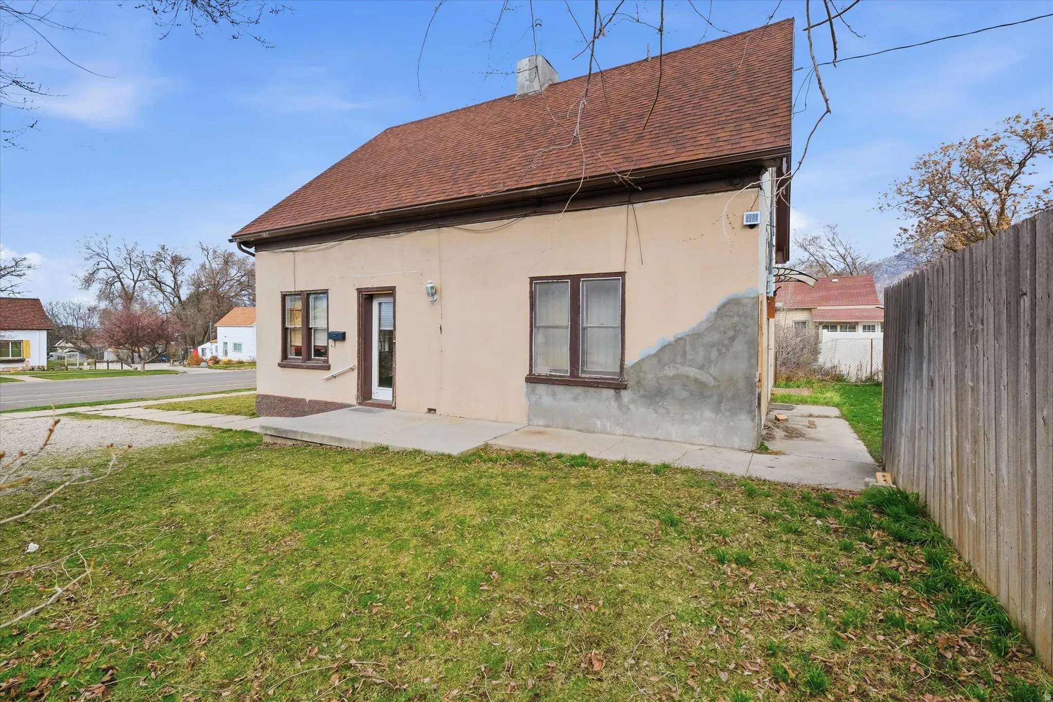 Rear view of house with roof with shingles, stucco siding, a chimney, and a patio