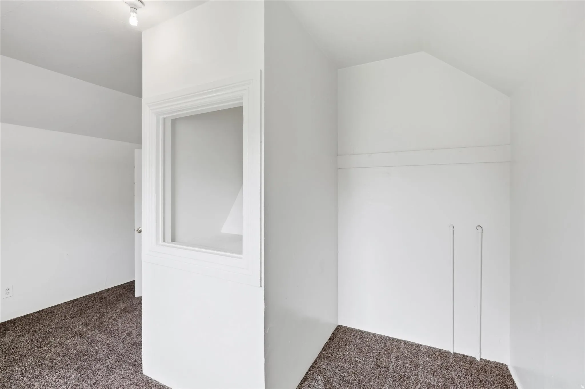 Additional living space featuring dark carpet and lofted ceiling
