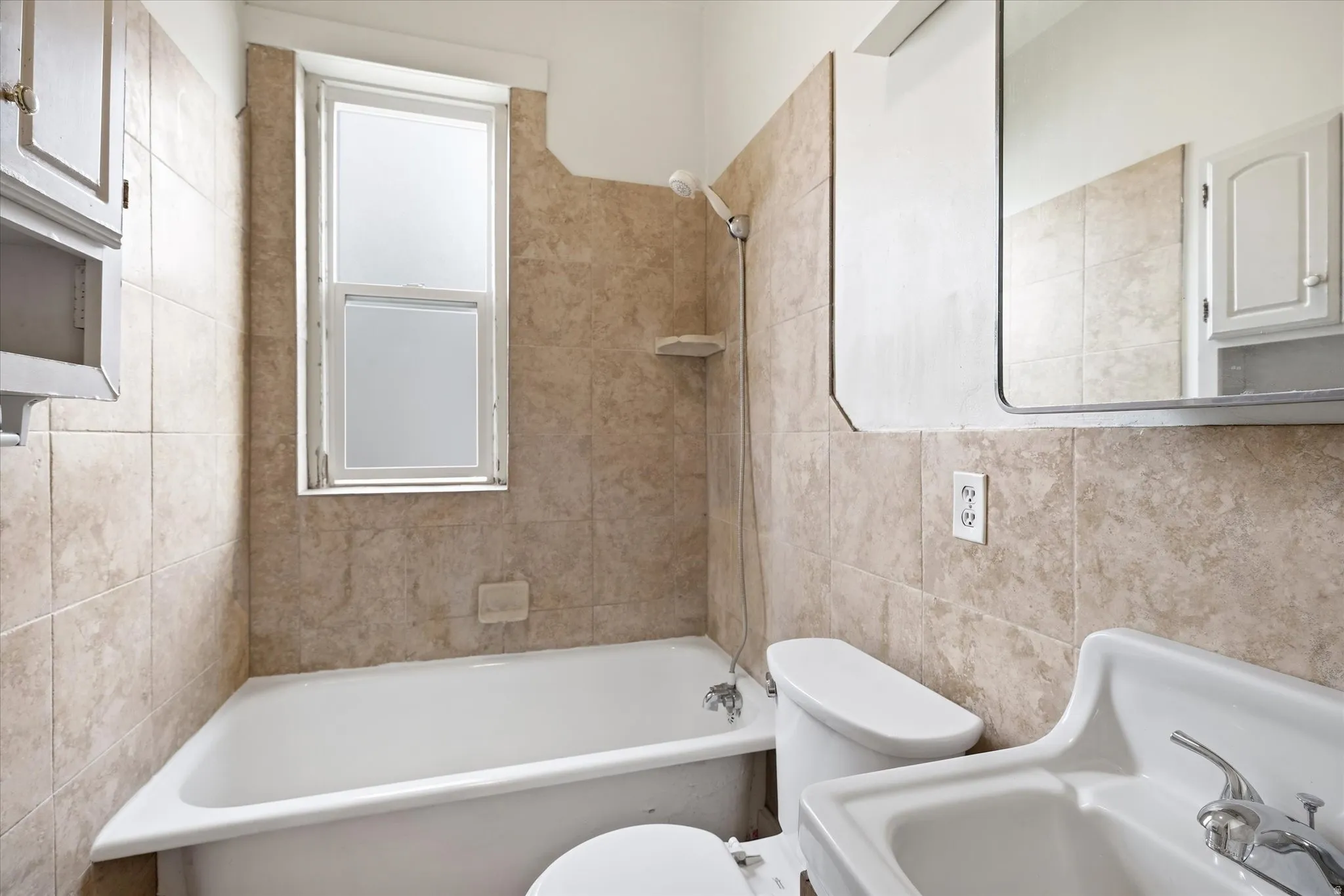 Full bathroom with bathtub / shower combination and tile walls