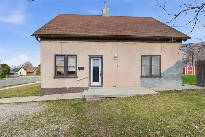 Rear view of property with a patio, roof with shingles, a lawn, and a chimney