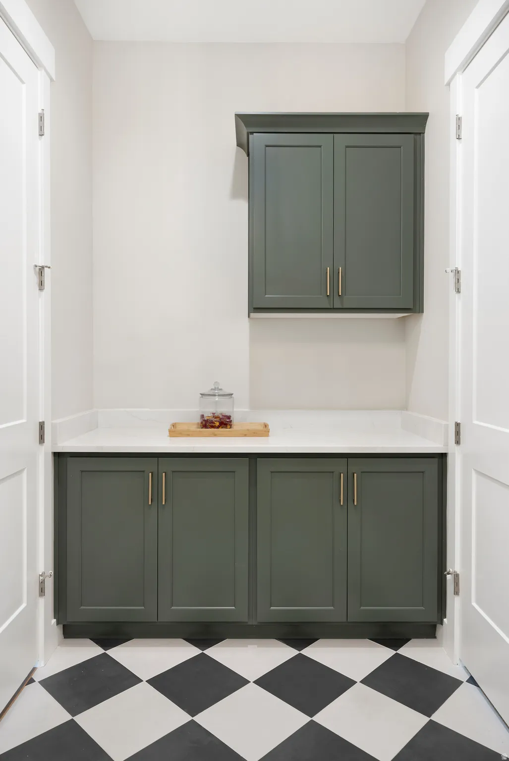 Bar area with green cabinetry, light floors, and light stone countertops