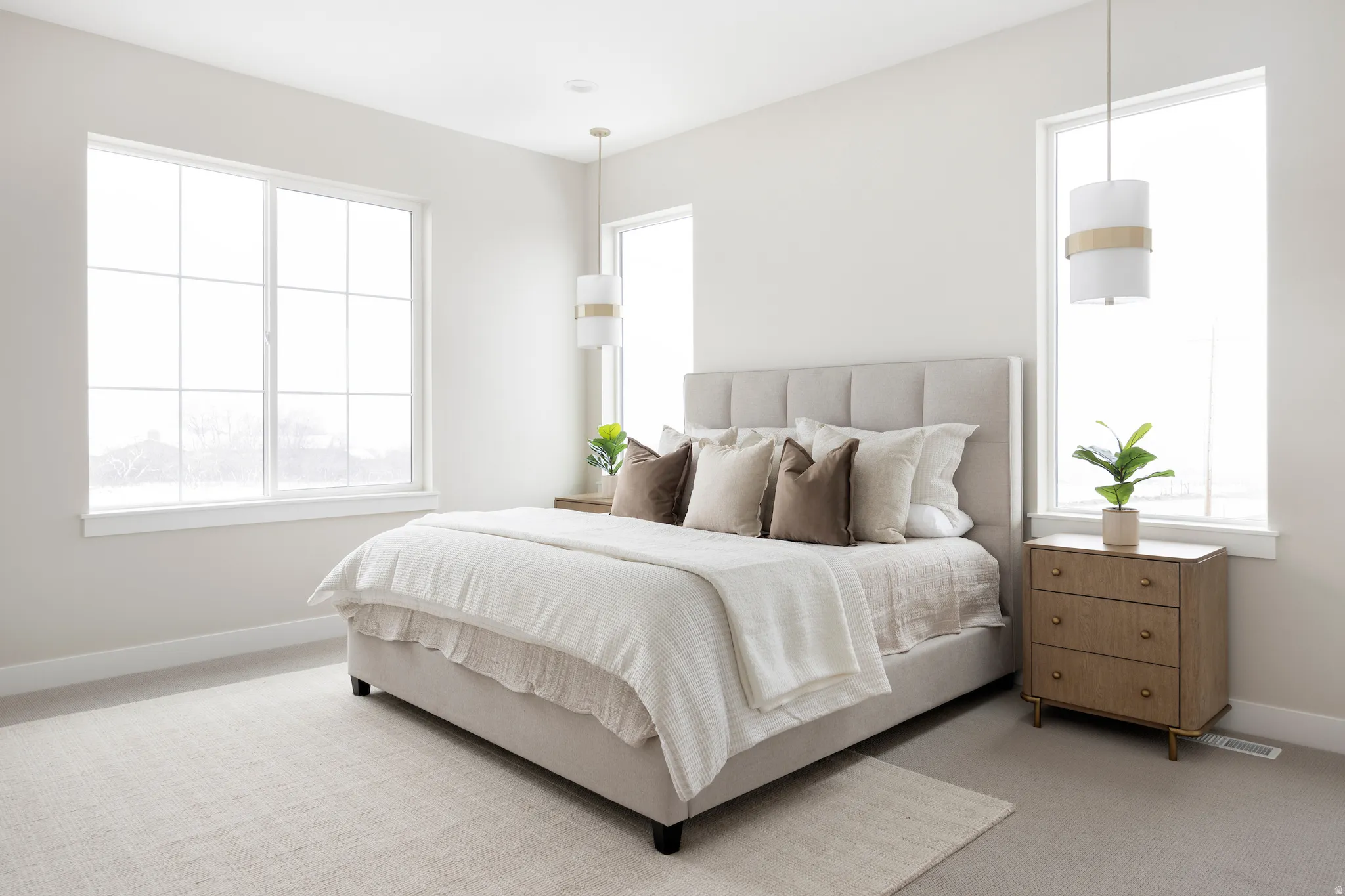 Bedroom with light colored carpet and multiple windows