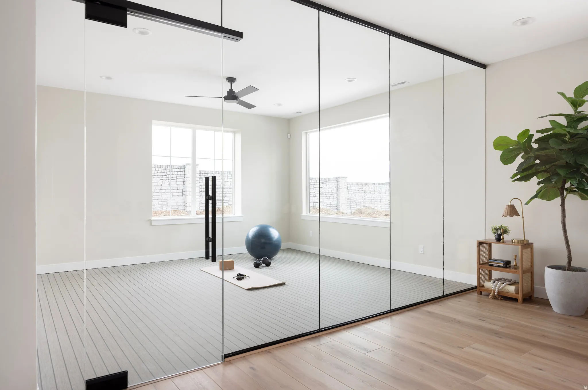 Workout area featuring light wood-style flooring, a ceiling fan, and recessed lighting