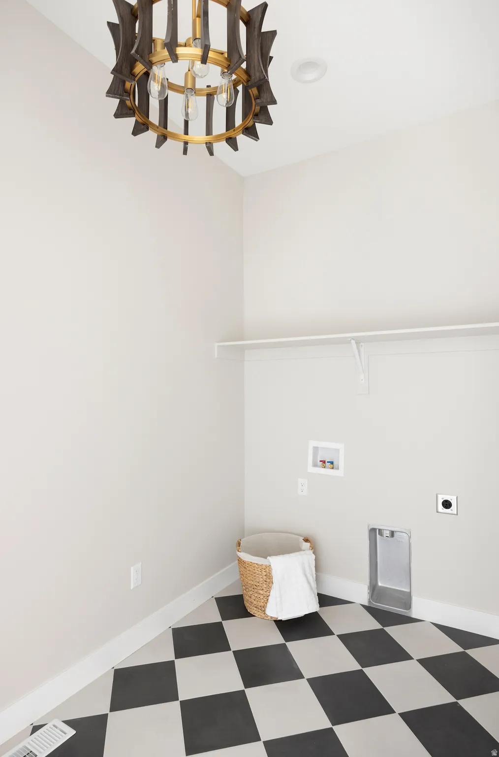 Laundry area with light flooring, electric dryer hookup, washer hookup, and a chandelier