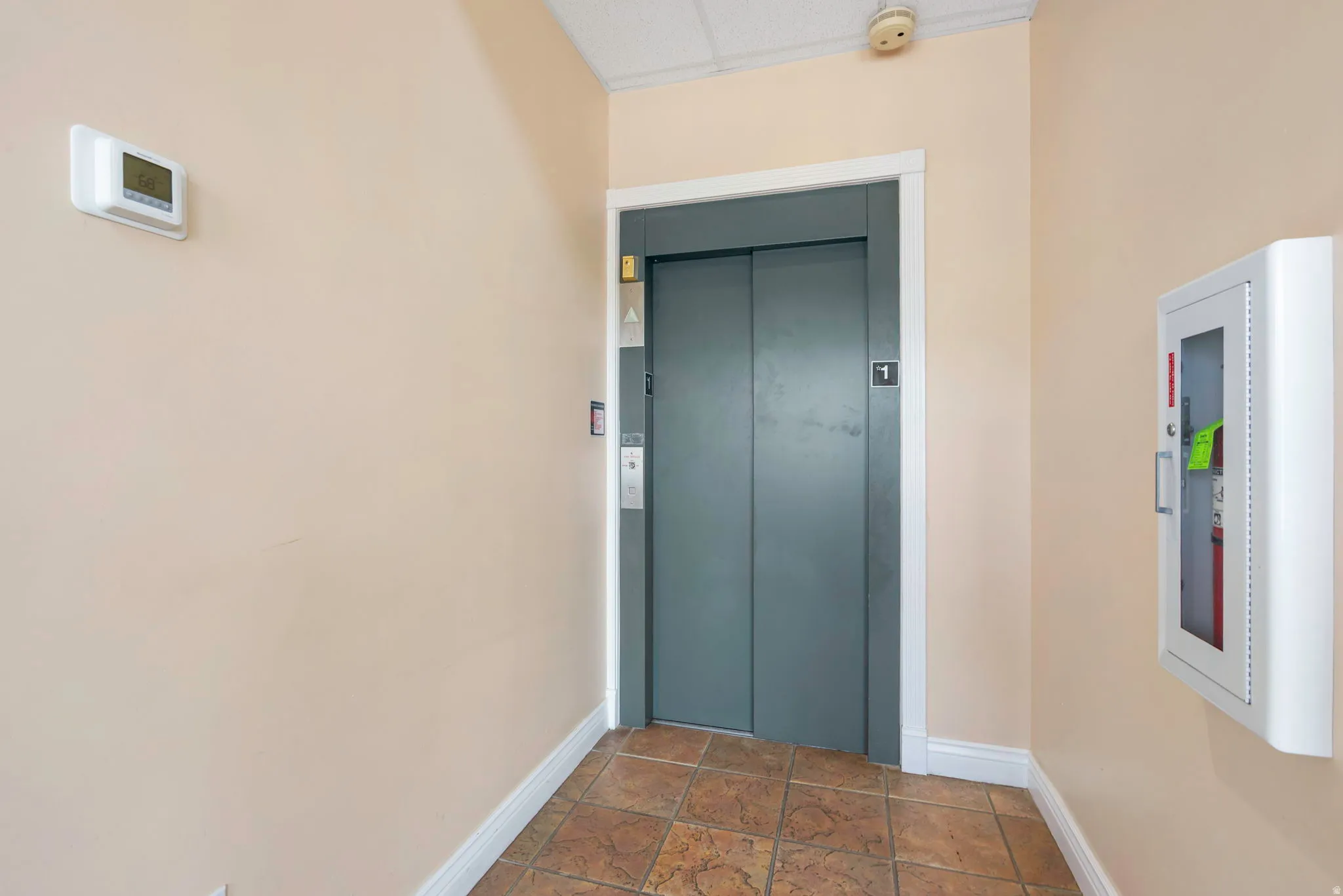Entrance to property featuring elevator and stucco siding