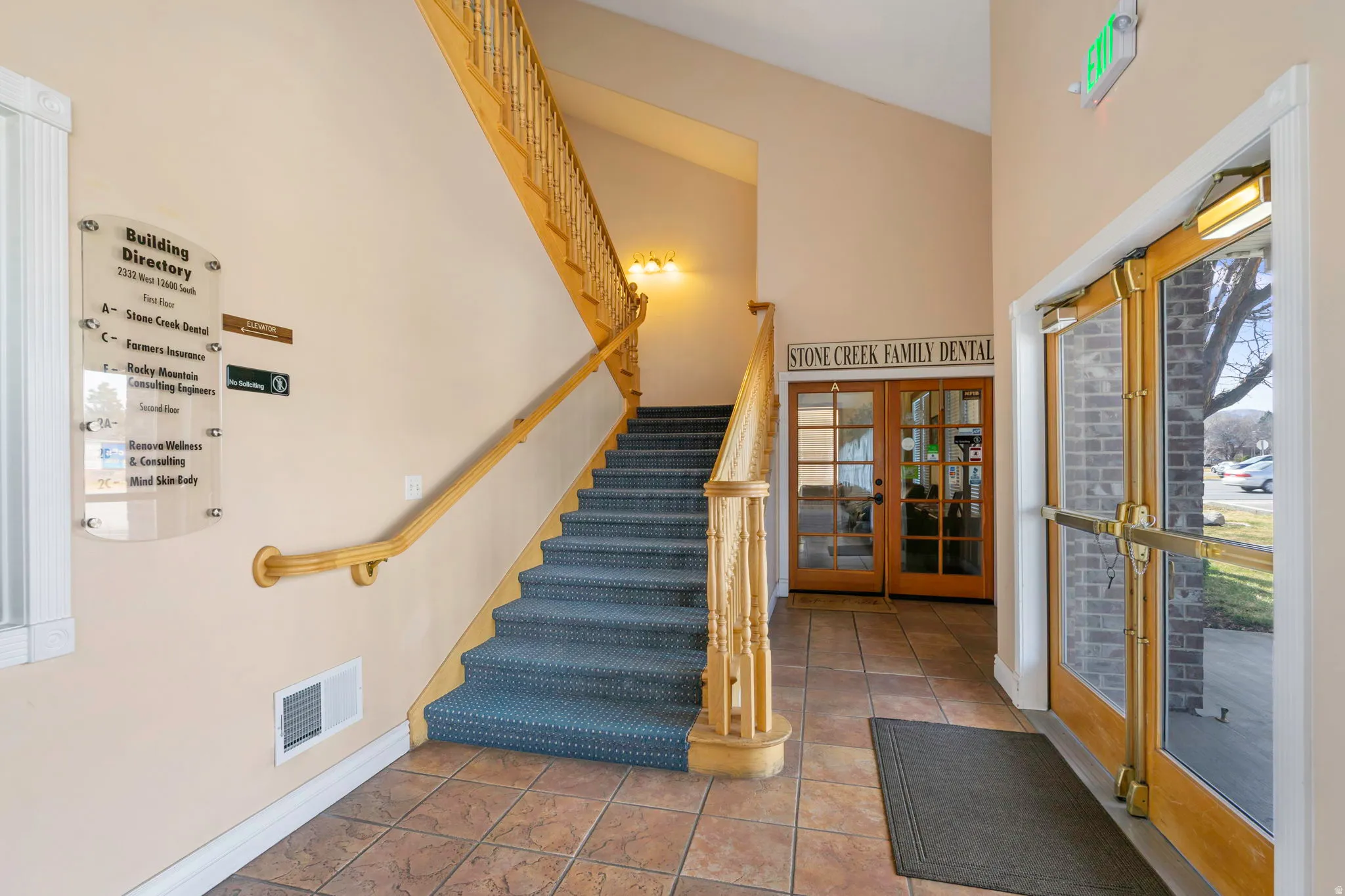 Stairway featuring french doors, plenty of natural light, tile patterned floors, and a high ceiling