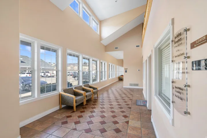 Corridor with baseboards and lofted ceiling