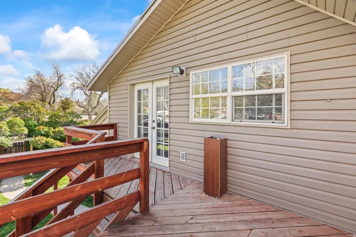 Exterior deck with natural wood flooring and railings