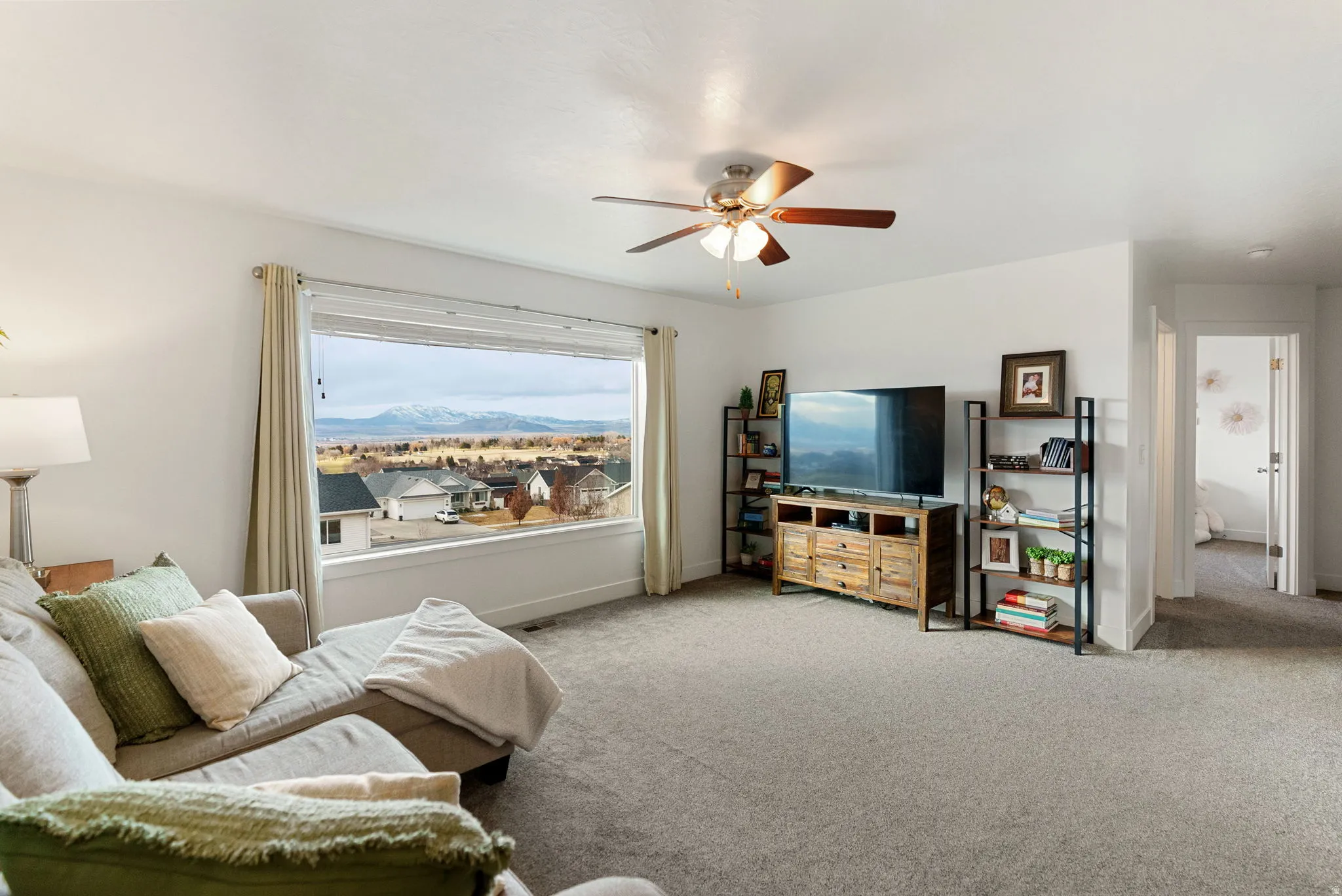 Living area featuring a ceiling fan and carpet