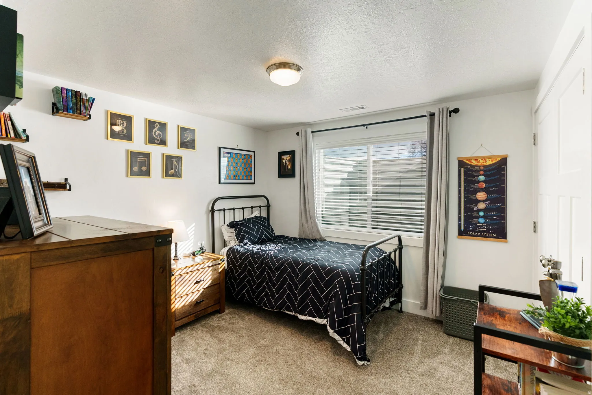 Bedroom with light colored carpet and a textured ceiling