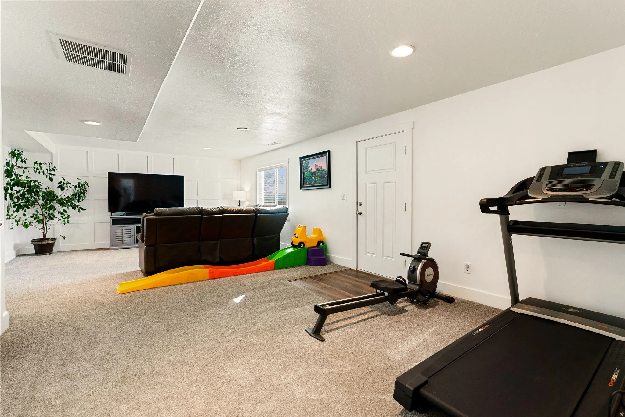Exercise room featuring carpet, a textured ceiling, and recessed lighting