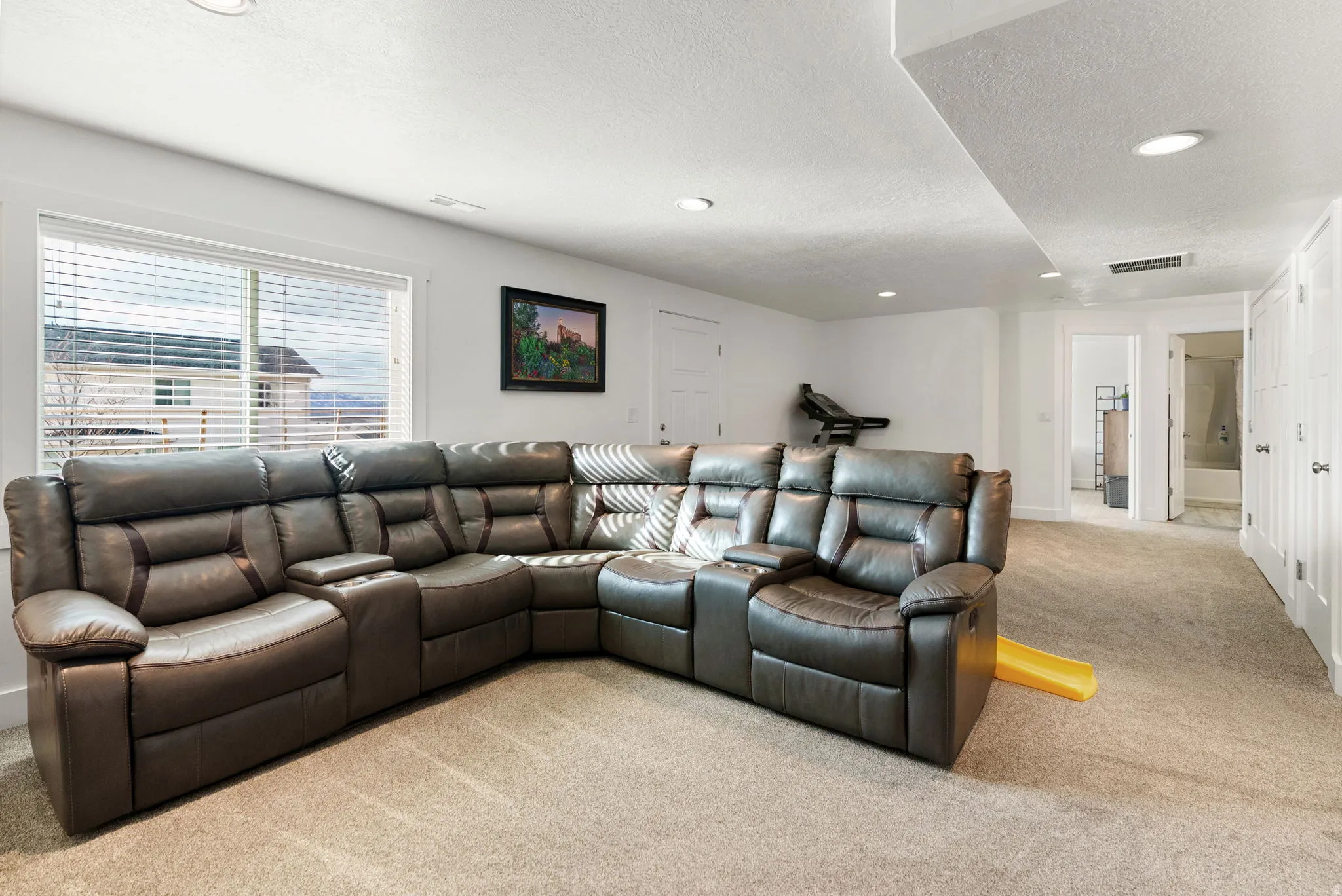 Living area featuring light carpet, recessed lighting, and a textured ceiling