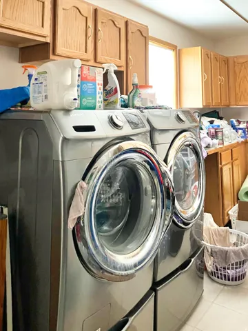 Laundry room featuring cabinet space, independent washer and dryer, and light tile patterned flooring