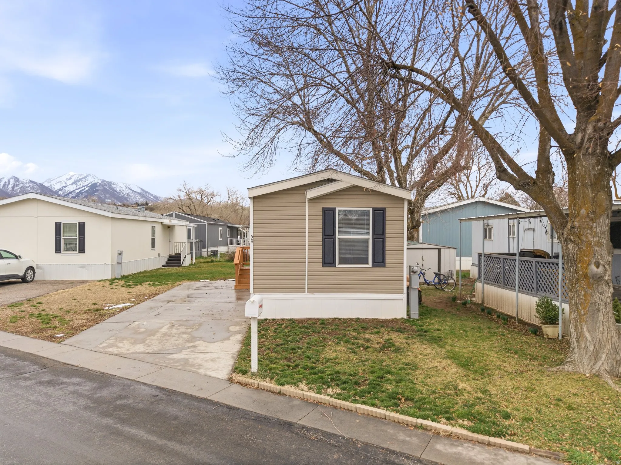 Manufactured / mobile home with a mountain view and a front lawn