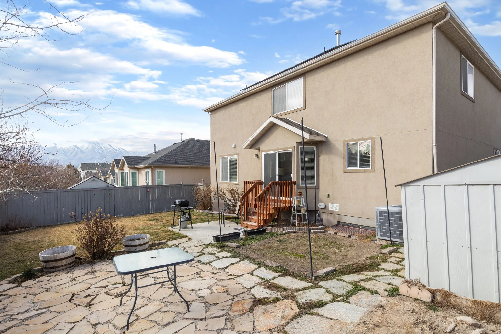 Back of property with a patio, a shed, a fenced backyard, and stucco siding