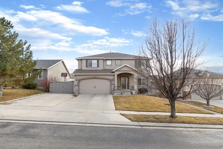 Traditional-style home with driveway, stucco siding, a gate, stone siding, and a garage