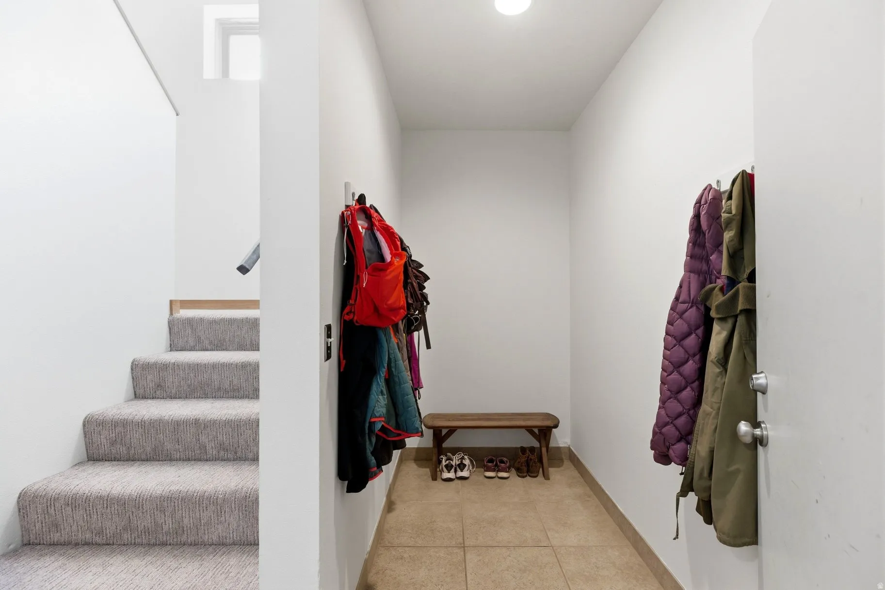 Stairway featuring tile patterned floors and baseboards