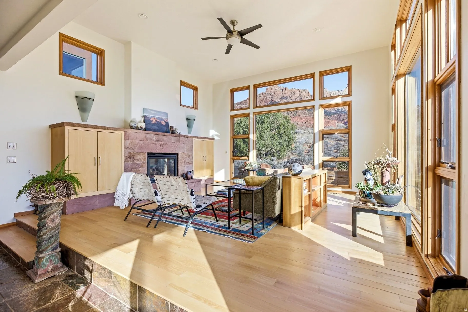 Office area with a high ceiling, a premium fireplace, ceiling fan, hardwood / wood-style floors, and healthy amount of natural light