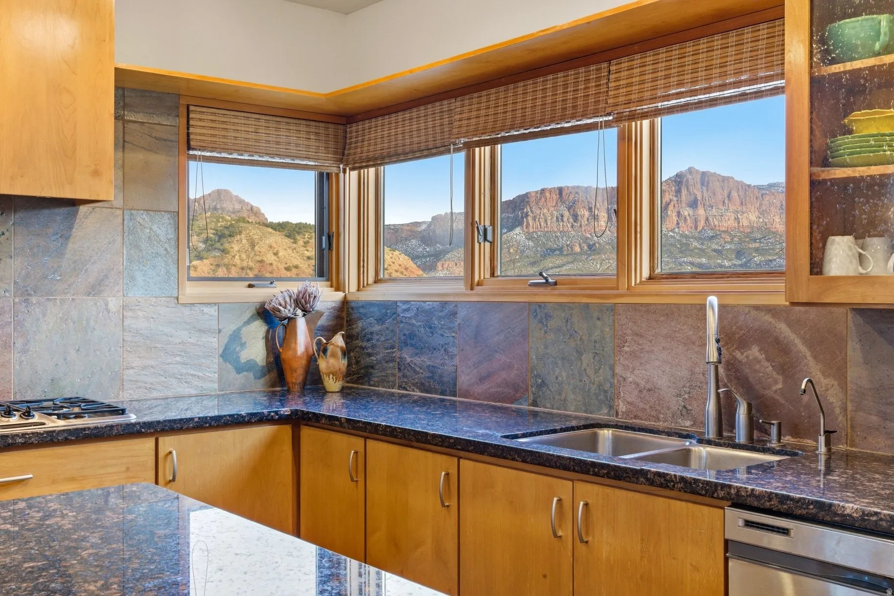 Kitchen featuring dark stone countertops, backsplash, wood finish cabinets, stainless steel appliances, and a mountain view