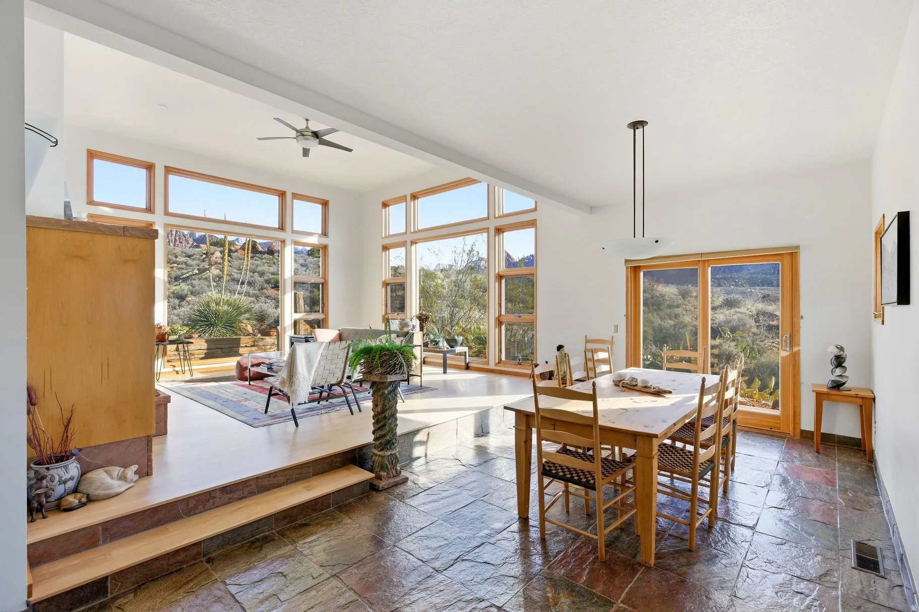 Dining space with stone tile floors and ceiling fan