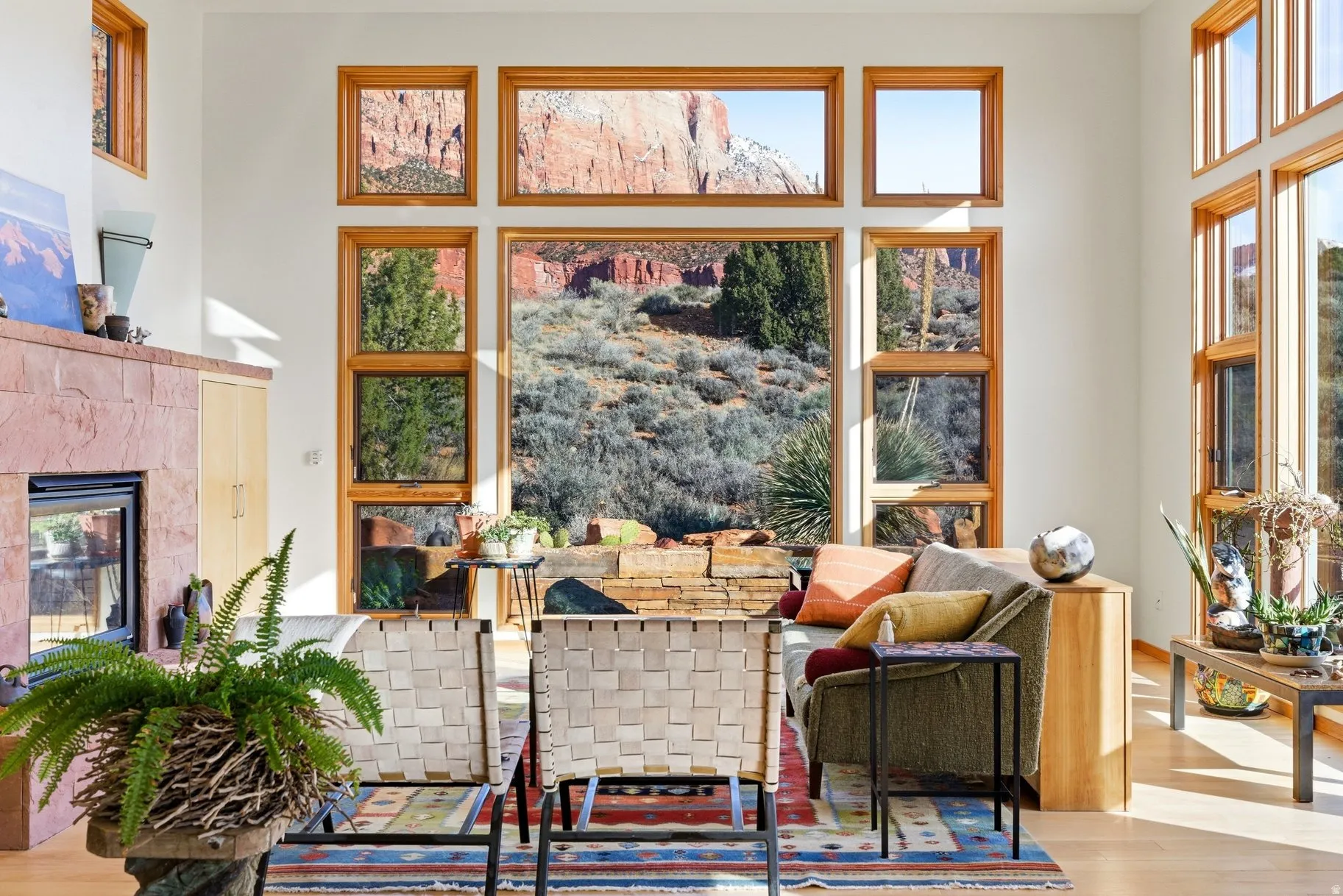 Sitting room with wood finished floors, a high ceiling, and a glass covered fireplace