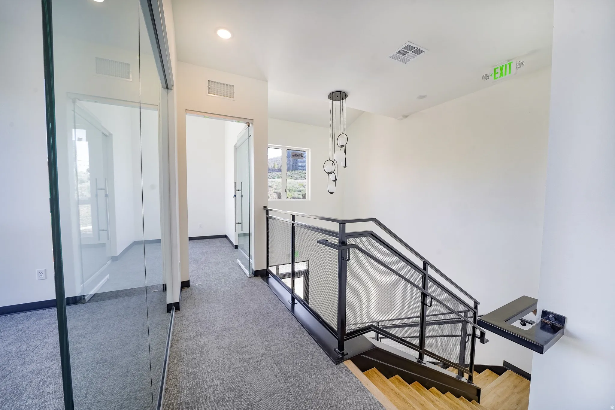 Hallway featuring an upstairs landing and light colored carpet