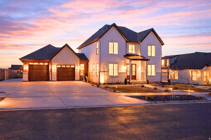 View of front facade featuring concrete driveway, a garage, and a metal roof