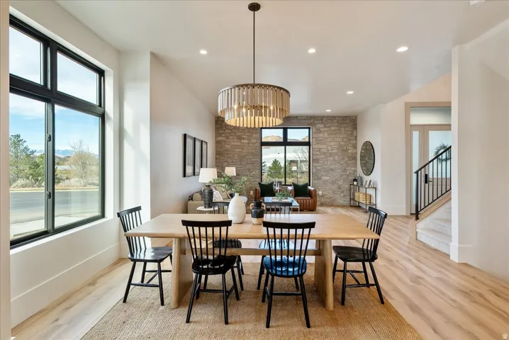 Dining area with light wood-style flooring and suspended lighting