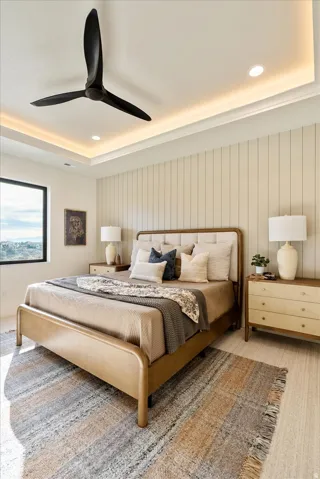 Bedroom featuring light carpet, ceiling fan, a tray ceiling, and recessed lighting