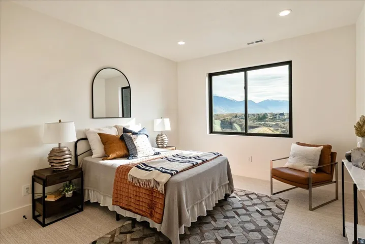 Bedroom with a mountain view, recessed lighting, and light colored carpet