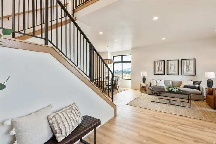 Living room with light wood-type flooring and recessed lighting